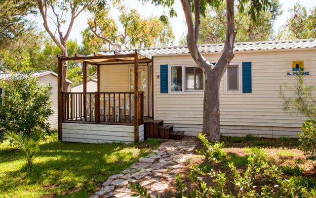 Casa mobile con veranda in un ambiente verde e alberato.